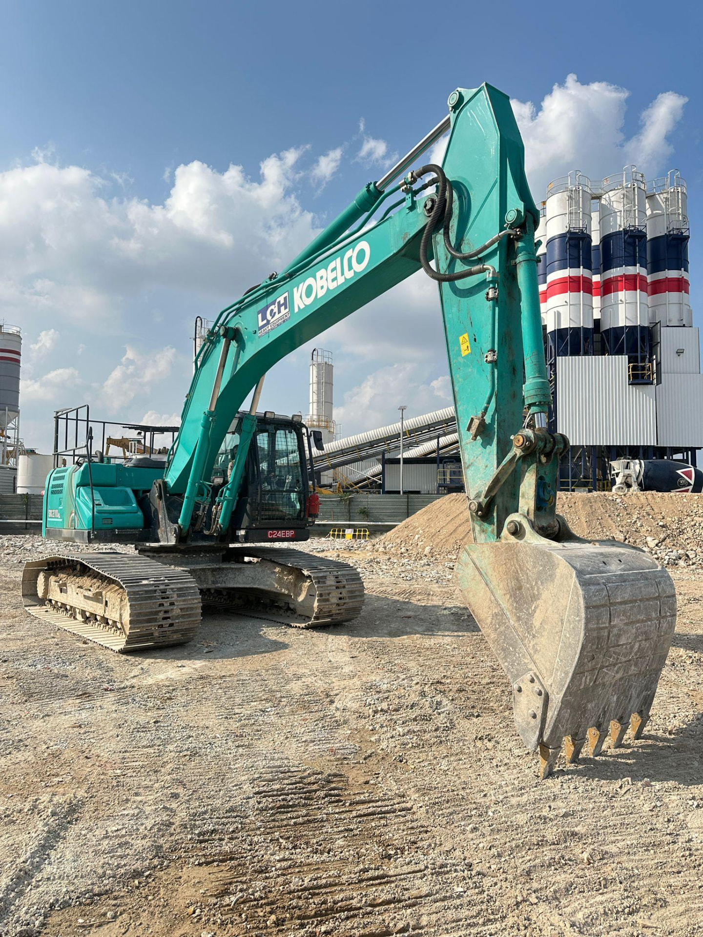 Excavator forming a drainage trench on a Singapore construction site